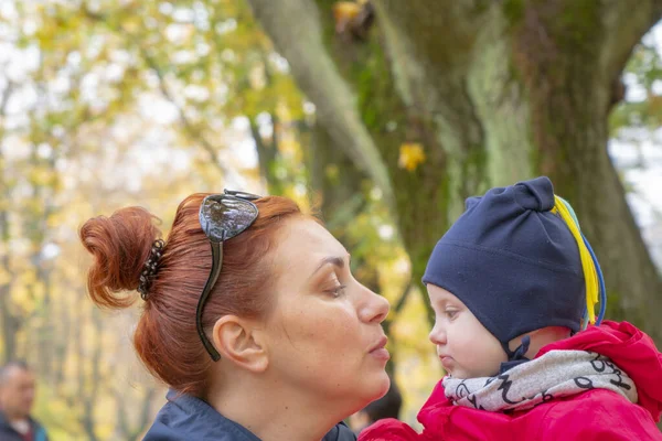 Autumn.moeder met kind op de handen van kijken op elkaar en glimlach Rechtenvrije Stockafbeeldingen