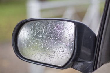 Araba yan aynası, su damlaları yakın.