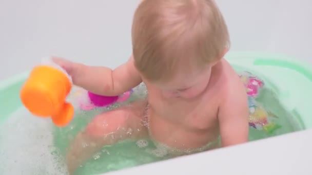 Kleines Mädchen mit blonden Haaren badet im Badezimmer — Stockvideo