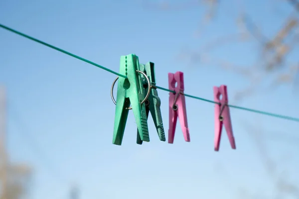 Clothespins for drying clothes hang on a rope — Stock Photo, Image