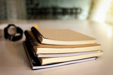 Kitap ve güneş ışığı, kopya alanı ile ahşap masa üzerinde kol saati.