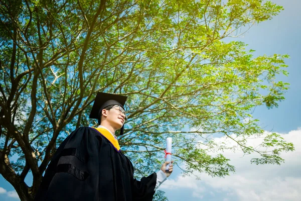 Afstuderen: Student opstaan en glimlach holding afstuderen cer — Stockfoto