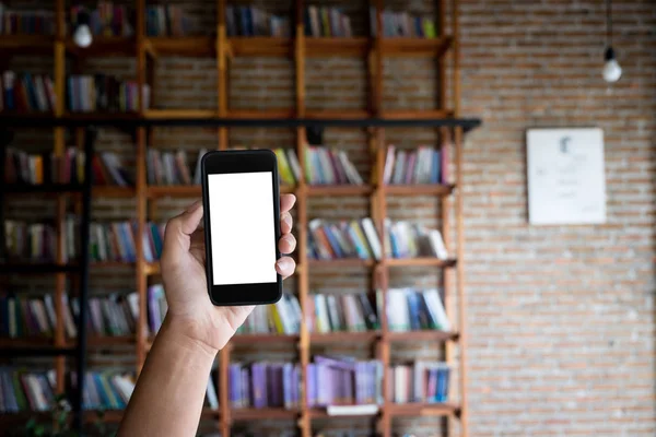 Homem segurando tela em branco de um smartphone na biblioteca . — Fotografia de Stock