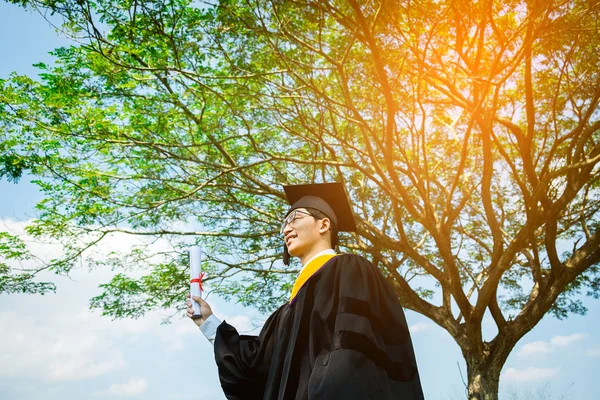 Αποφοίτησης: Φοιτητής όρθιοι και χαμόγελο κρατώντας αποφοίτηση cer — Φωτογραφία Αρχείου