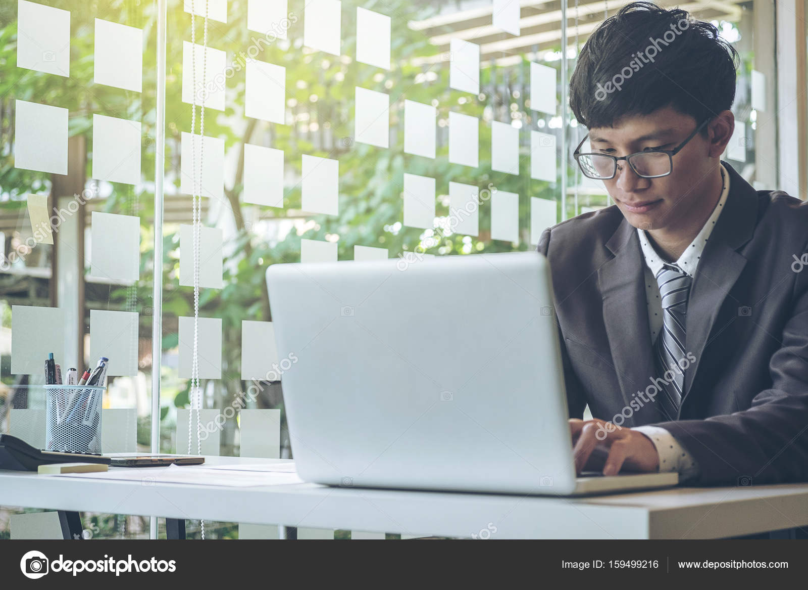 Un jeune homme d'affaires confiant travaillant sur un ordinateur