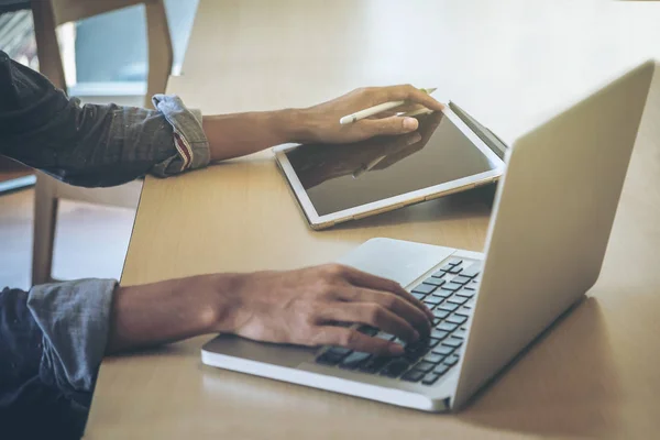 Primer plano de la mano masculina, utilizando la tableta digital y el ordenador mientras s — Foto de Stock