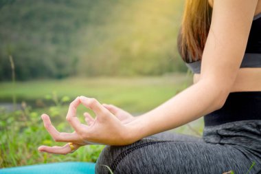 Yoga nehir kenarında oturan bir genç bayan. Sağlıklı lifestyl kavramı