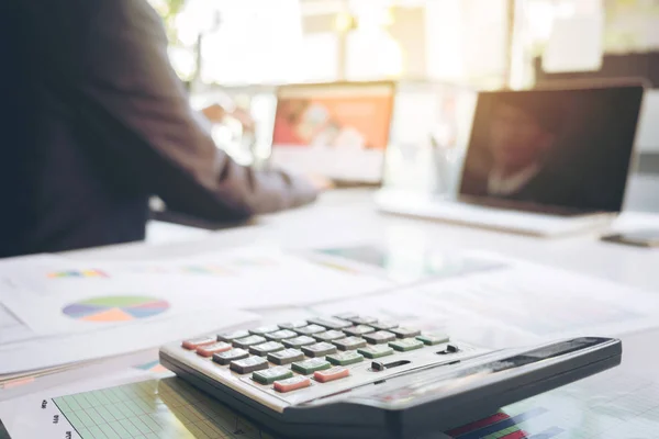 Podnikatel, pomocí notebooku a kalkulačka na kancelářský stůl a mnozí — Stock fotografie