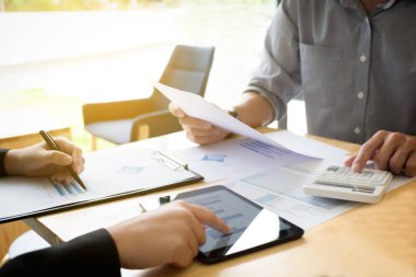Ekip çalışması süreci, hesap makinesini kullanarak ve iş stratejisi dijital tablet ile tartışmak için toplantı iki iş meslektaşım. Toplantıya, beyin fırtınası, danışmanlık.