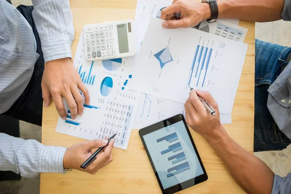 Due uomini d'affari che calcolano la fattura fiscale, il grafico della strategia aziendale e utilizzano la calcolatrice sulla scrivania di legno, processo Coworker . — Foto Stock