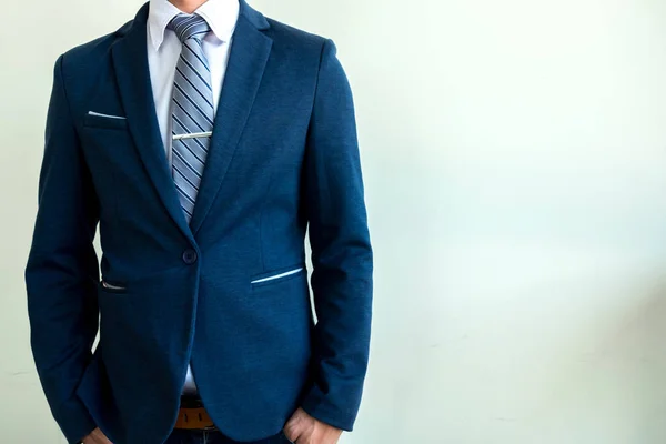 Бизнесмен в синем костюме стоит на бетонном фоне — стоковое фото