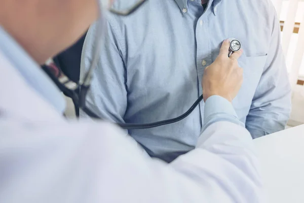 Primer plano del médico escuchando los latidos cardíacos del paciente con estetosco —  Fotos de Stock