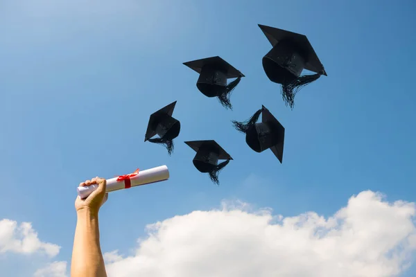 Día de graduación, imágenes de la mano con un certificado y gorras o — Foto de Stock
