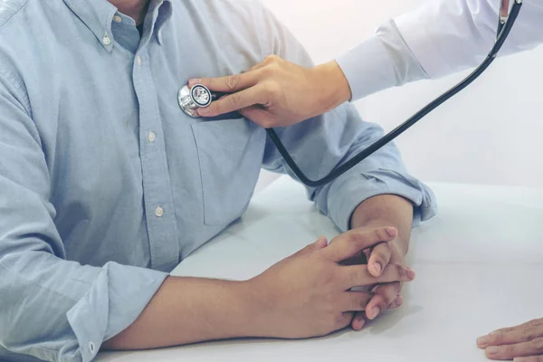 Doktor stethosco ile hasta kalp atışlarını dinlerken yakın çekim — Stok fotoğraf