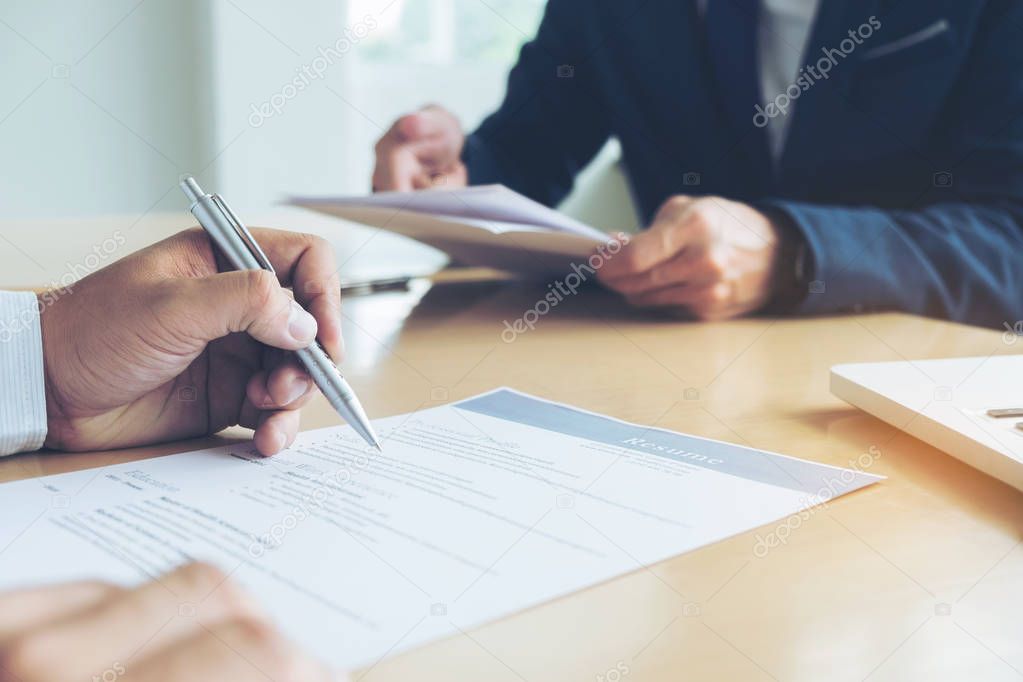 Executive reading a resume during a job interview and businessma