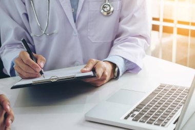 Bir doktor hasta danışmanlık sırasında bir geçmişi formu doldurarak kadar yakın ve tedavi yöntemleri ve nasıl vücut rehabilite için tavsiye.