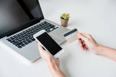 Mutlu kadın akıllı telefon ve kredi kartı kullanarak kayıt ödemeleri 