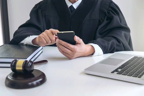 Мужской адвокат или судья, работающий со смартфоном и весами — стоковое фото