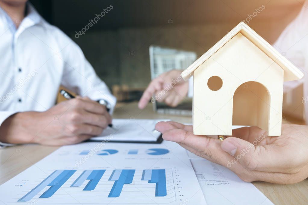 Man sign a home insurance policy on home loans, Agent holds home