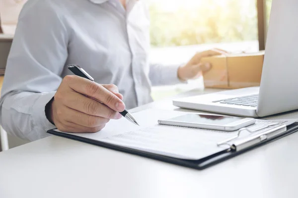 Hombre vendedor escribir un producto de la orden para prepararse para la entrega a cust — Foto de Stock