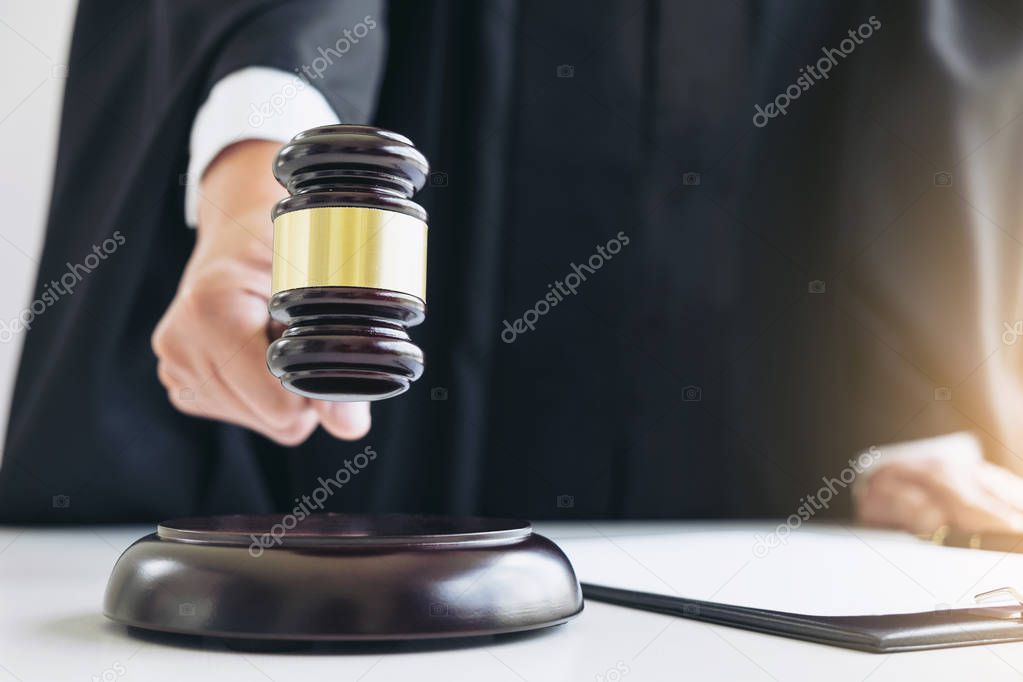 Close up of Male lawyer or judge hand's striking the gavel on so