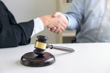 Eller, erkek avukat ya da yargıç ve istemci üzerinde el sıkışan görüntü