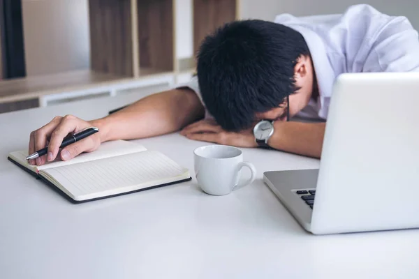 Tired businessman sleeping while working with laptop and writing — Stock Photo, Image