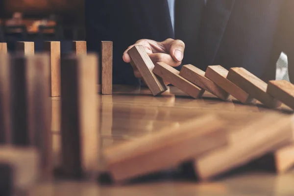 Primer plano de la mano del hombre de negocios Detener la caída de madera Dominó ef —  Fotos de Stock