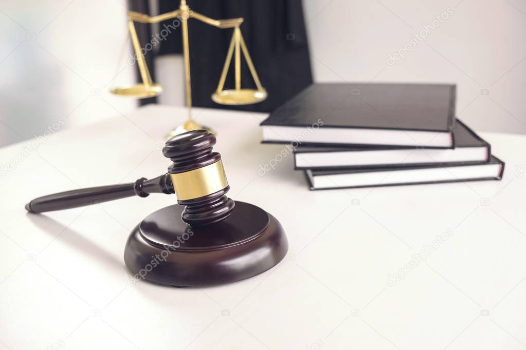 Attorney's suit, Law books, a gavel and scales of justice on a w