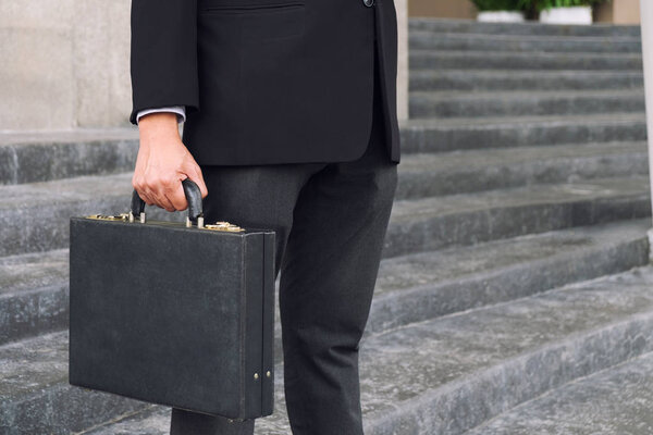 Businessman standing and holding a briefcase in hand working wit