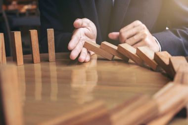 İşadamı el ahşap Domino ef durdurma düşen yakın çekim