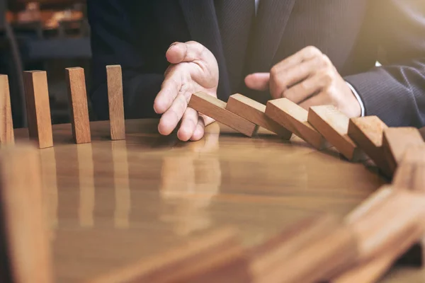 Primer plano de la mano del hombre de negocios Detener la caída de madera Dominó ef —  Fotos de Stock