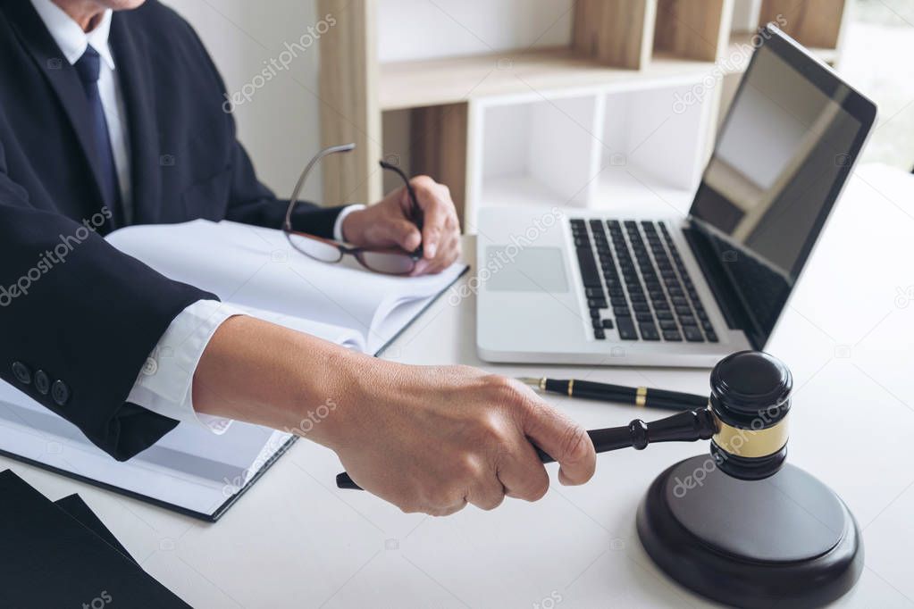 Close up of Male lawyer or judge hand's striking the gavel on so