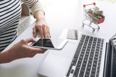 Mutlu kadın akıllı telefon ve kredi kartı kullanarak kayıt ödemeleri 