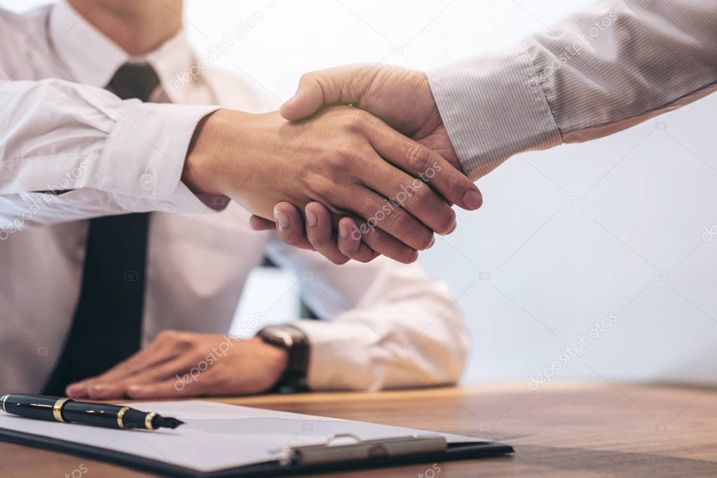 Real estate broker agent and customer shaking hands after signin