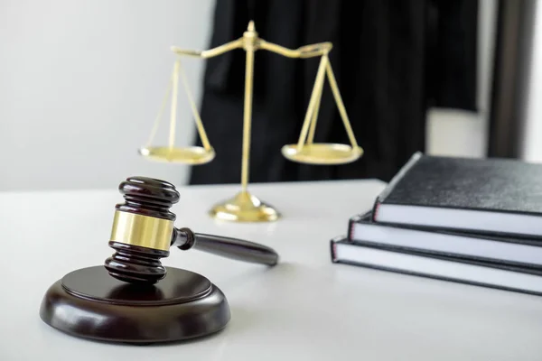 Anwaltsanzug, Gesetzesbücher, ein Hammer und eine Waage der Gerechtigkeit auf einem w — Stockfoto
