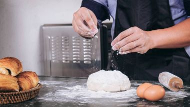 Adam el ING ile taze hamur üzerine un yağmurlama yakın çekim