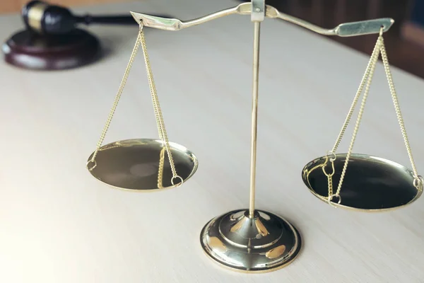 Close-up de escalas de justiça e martelo sobre mesa de madeira em um cou — Fotografia de Stock