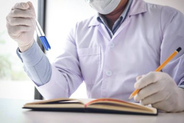 Bilim adamı veya tıbbi laboratuar önlüğünü tüp ile reaktif holding içinde,