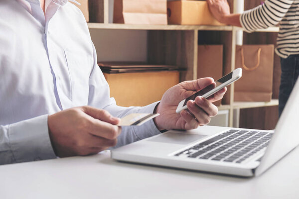 Man using smart phone and credit/debit card register payments on
