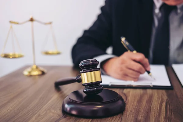 Hamer op de houten tafel en advocaat of rechter werken met overeenkomst — Stockfoto