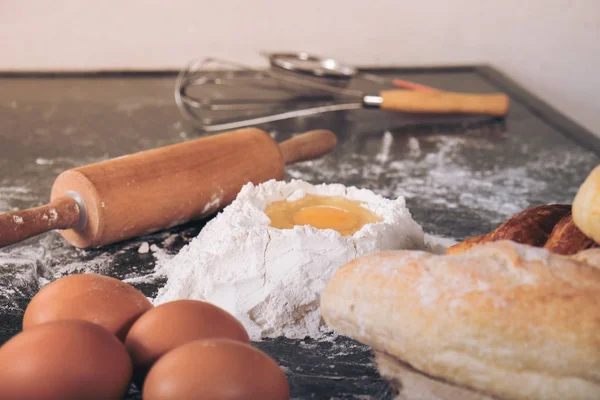 Ruwe deeg voor brood met ingrediënten op zwarte achtergrond — Stockfoto