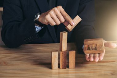 İşadamı el olarak yığma ahşap bloklar kalkınma düzenlenmesi