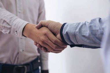 Ofiste bir toplantı sırasında el sıkışan iki iş adamları,