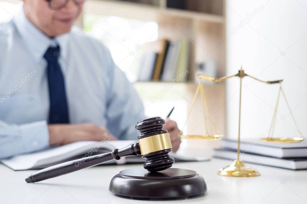 Judge gavel with scales of justice, male lawyers working having 