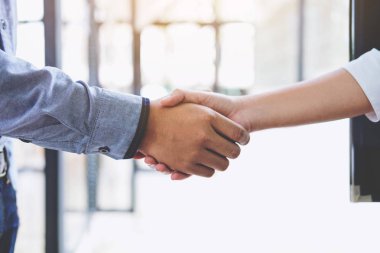 Ofiste bir toplantı sırasında el sıkışan iki iş adamları,