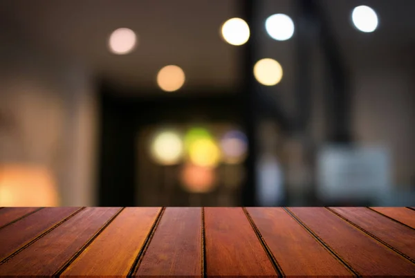 Boş ahşap masa ve bulanık arka plan önünde o soyut — Stok fotoğraf