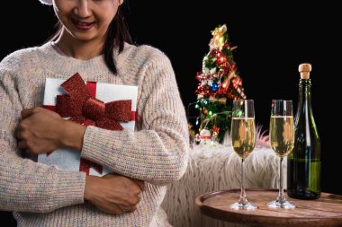 Güzel kadınlar hediye kutuları ve iki bardak şampanya ile tutarak