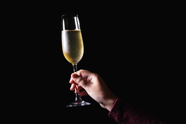 Mulher mão segurando copos de champanhe no fundo preto — Fotografia de Stock