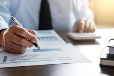 Erkek muhasebeci hesaplamalar ve mali grafik verilerini çözümleme 